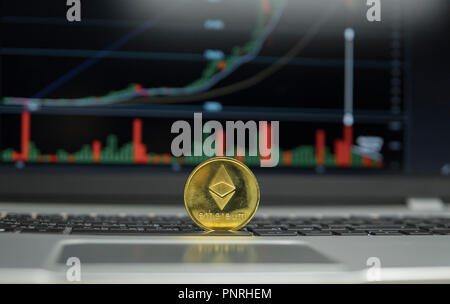 Goldene Münze des Astraleums auf einer Tastatur, schwarz silber Laptop und Diagramm Diagramm Diagramm auf ein Bild als Hintergrund. Virtuelle cryptocurrency Konzept. Abbau von ethereums online Bussiness. Handel. Stockfoto