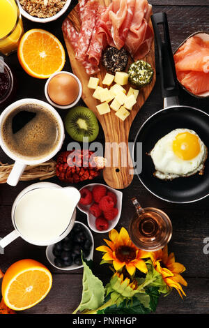 Frühstück am Tisch mit Brot, Brötchen, Croissants, Kaffee und Saft Stockfoto