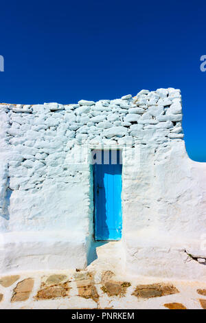 Kleine schmale blaue Tür im Alten getünchte Wand, Mykonos, Griechenland Stockfoto