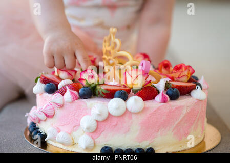 Die Hand des Babys zeigt Kuchen Dekorationen. Nahaufnahme. Stockfoto