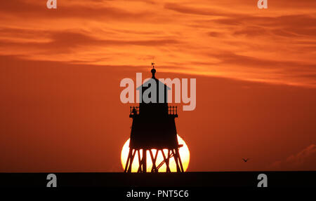 Die Herde Groyne Leuchtturm in South Shields an der nordöstlichen Küste bei Sonnenaufgang. Heftige Regenfälle und starke Windböen, die durch Sturm Bronagh eingestellt sind über das Wochenende zu erleichtern, da das Wetter in der Nordsee bewegt, Meteorologen gesagt haben. Stockfoto