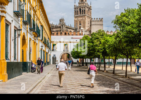 Touristen wandern in Patio de Banderas Square, mit dem Glockenturm Giralda in Sevilla, Spanien. Stockfoto