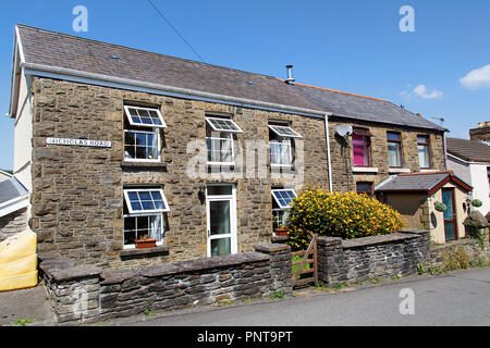 Swansea, Großbritannien: Juli 07, 2018: Street View der typische doppelte Fassade Reihenhaus in einem walisischen Dorf. Sommer mit Garten Blumen und blauer Himmel. Stockfoto