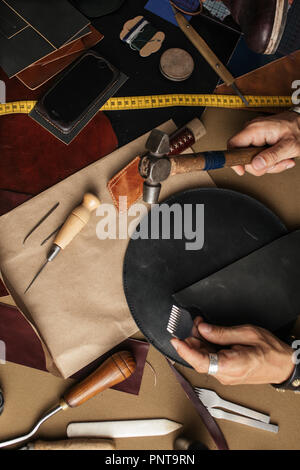 Nahaufnahme von skinner Handwerker arbeiten mit natürlichen Leder mit craft Tools. Stockfoto