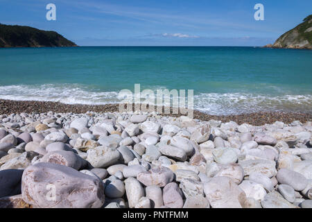 Asturien, Spanien. Kiesstrand mit türkisblauem Meer im Hintergrund. Stockfoto