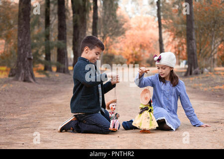 Junge und Mädchen spielen in den Park mit der rag dolls Stockfoto