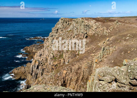 Carn Les Boel, Landspitze Detail, entfernte Longships Leuchtturm & Küste Weg; Cornish Coast in der Nähe von Lands End. Carn Les Boel, in der Nähe von Lands End, Cornwall, UK. Stockfoto