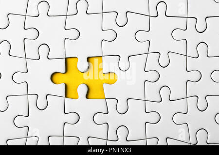 Das letzte Stück des Puzzles legen die Mission auf gelbem Hintergrund abzuschließen Stockfoto