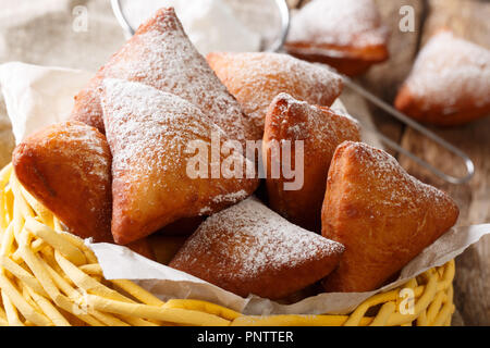 Weiche Mandzi - East African Donuts mit Kokosraspeln, gewürzt mit Kardamom, Muskat und Fried in Perfektion close-up in einem Korb auf einem Tisch. Stockfoto