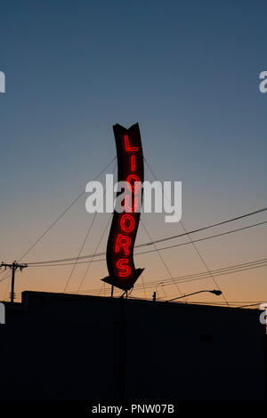 Ein Roter Neon Liköre Store anmelden glühende bei einem Sonnenuntergang. Stockfoto