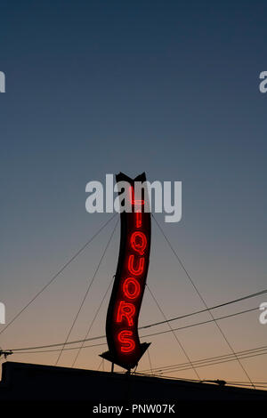 Ein Roter Neon Liköre Store anmelden glühende bei einem Sonnenuntergang. Stockfoto