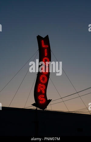 Ein Roter Neon Liköre Store anmelden glühende bei einem Sonnenuntergang. Stockfoto