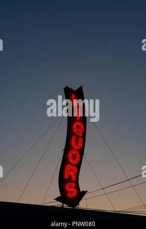 Ein Roter Neon Liköre Store anmelden glühende bei einem Sonnenuntergang. Stockfoto