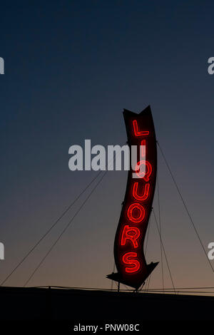 Ein Roter Neon Liköre Store anmelden glühende bei einem Sonnenuntergang. Stockfoto