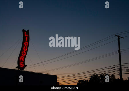Ein Roter Neon Liköre Store anmelden glühende bei einem Sonnenuntergang. Stockfoto