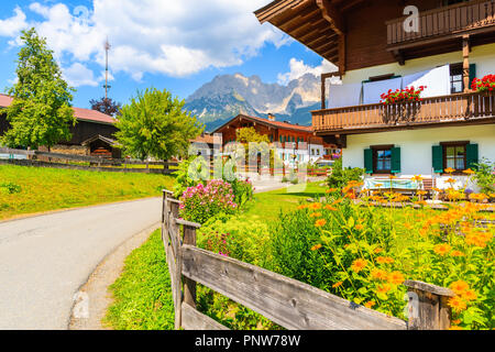 Straße in Going am Wilden Kaiser Dorf auf sonnigen Sommertag und schöne traditionelle Häuser mit Blumen dekoriert, Tirol, Österreich Stockfoto