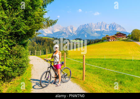 Kitzbühel, Österreich - May 30, 2018: Junge Frau Radfahrer für Bild im schönen Sommer Landschaft der Alpen, Österreich aufwirft. Stockfoto