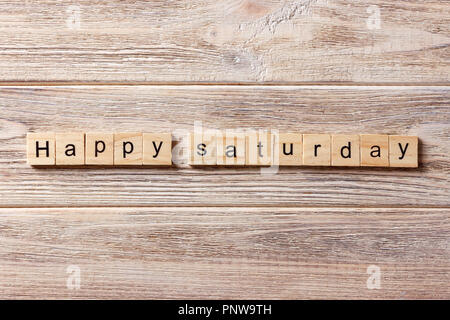 Happy Samstag Wort auf Holz Block geschrieben. Happy Samstag text auf Tisch, Konzept. Stockfoto