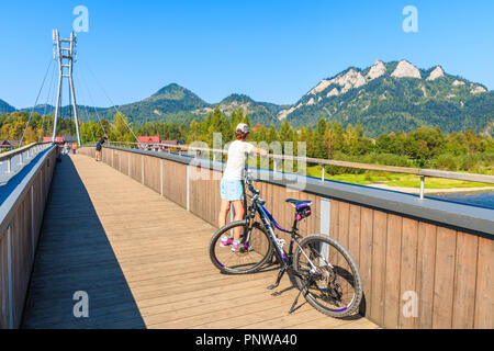 PIENINY, Polen - 19.September 2018: Junge Frau Radfahrer auf der Brücke Blick auf Trzy Korony (Drei Kronen) an sonnigen Herbsttag, Pieniny, Stockfoto