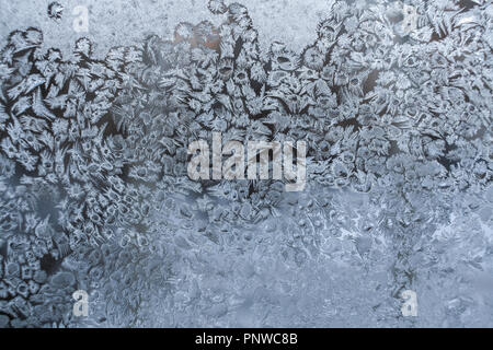 Snowy frosty Muster wie große Ansammlung von kleinen ungewöhnliche Schneeflocken im Winter Fenster. Stockfoto