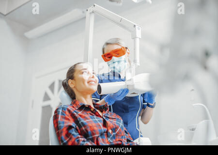 Kunden Lächeln beim Zahnarzt in der blauen Uniform Holding x-ray. Stockfoto