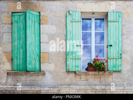 Rustikale französische Fensterläden mit auf offenen und eine mit Pflanzen auf der Fensterbank geschlossen Stockfoto