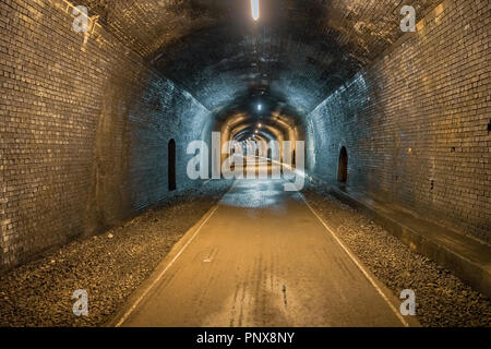 Zu Fuß durch den Grabstein Tunnel, in der Nähe der Monsal Kopf in den East Midlands, Derbyshire, Peak District, England, Großbritannien Stockfoto