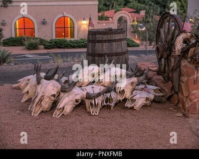 Buffalo Schädel vor einem Faß und Wagenrad in Sedona, Arizona. Stockfoto