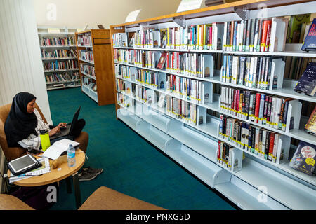 West Palm Beach Florida, Mandel Öffentliche Bibliothek, innen, Bücher Bücherregale, Muslime, Asiaten ethnischen Einwanderer Minderheit, Erwachsene Erwachsene Stockfoto