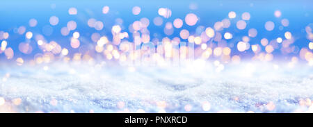 Weihnachtsbeleuchtung Defokussierten auf Schnee Stockfoto