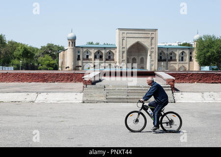 Taschkent, Usbekistan - Mai 02, 2017: Unbekannter alter Mann auf einem Fahrrad in der Nähe der Medrese. Stockfoto