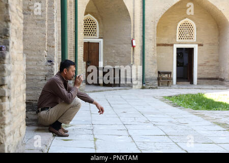 Taschkent, Usbekistan - Mai 02, 2017: Unbekannter usbekischen Mann sitzen und Tee trinken an der Medrese. Stockfoto