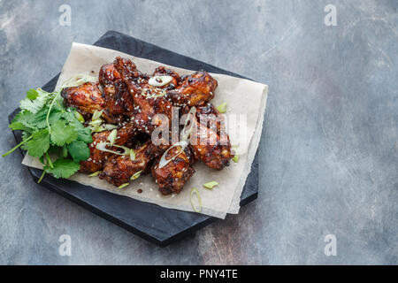 Gebackene Chicken Wings mit Sesam und Soße. Essen Hintergrund mit kopieren. Ansicht von oben. Stockfoto