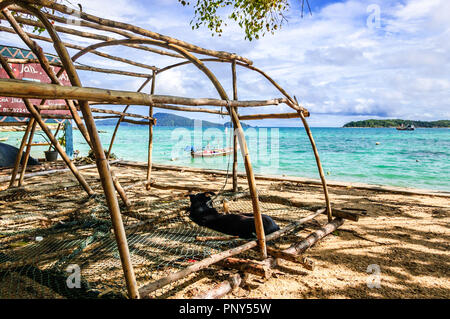 Rawai Beach, Phuket, Thailand - Oktober 27, 2013: Hund liegt im Schatten auf fischfalle Netting, Rawai Beach, Phuket, Thailand Stockfoto