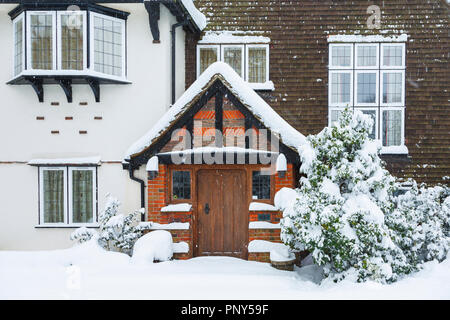 Holz Eiche Haustür und Halle ein großes Haus mit ungestörten Schneeverfrachtung bei starkem Schneefall im Winter, Woking, Surrey, Südosten, England, Grossbritannien Stockfoto
