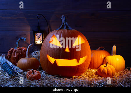 Geschnitzte Kürbisse oder Jack-o-lanterns in dunklen Scheune, Halloween Urlaub feier Konzept Stockfoto