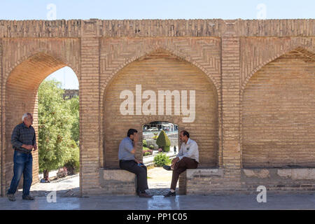 ISFAHAN, IRAN - August 7, 2015: Senior iranischen Menschen, Männer, Sitzen und diskutieren über die Bögen der Si-o-Seh Pol, eine der wichtigsten Brücken der Ci Stockfoto