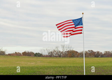 Eine amerikanische Flagge zu Ehren des Veterans' Tag entlang der Straße zum Missouri Veteranen nach Hause an einem bewölkten Spätherbst Nachmittag im November. Stockfoto