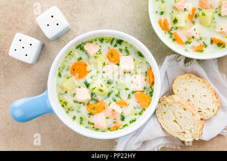 Frische hausgemachte cremige Lachs, Kartoffeln und Karotten Suppe in Schalen, weißbrotscheiben an der Seite, fotografiert Overhead (selektive Fokus) Stockfoto