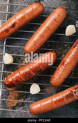 Frisch gekochte Würste auf dem Grill mit Knoblauch, Ansicht von oben Stockfoto