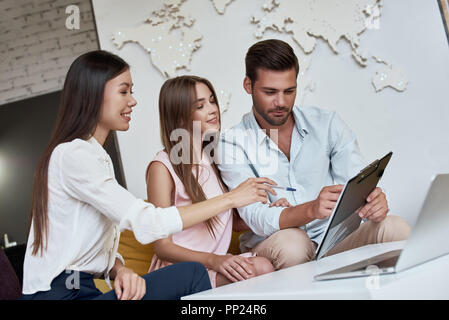 Junge paar schöne sitzend mit Manager im Reisebüro Büro- und Überprüfung der Vertrag für einen Sommerurlaub Stockfoto