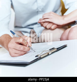 Junge paar schöne sitzend mit Manager im Reisebüro Büro- und unterzeichnen Vertrag für einen Urlaub. Close-up Konzept für Reisebüro Stockfoto