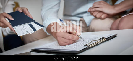 Junge paar schöne sitzend mit Manager im Reisebüro Büro- und unterzeichnen Vertrag für einen Urlaub. Close-up Konzept für Reisebüro Stockfoto