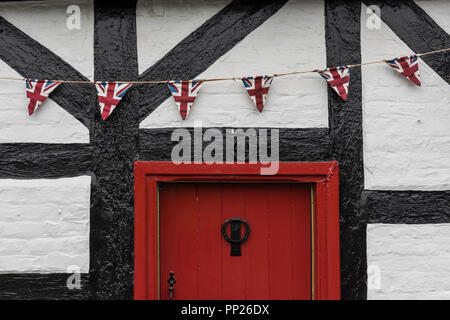 Union Jack dreieckige Bunting hängen auf der Vorderseite eines Hauses in Beaton, Cheshire, England, Großbritannien Stockfoto