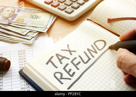 Steuerrückerstattung handschriftlich in den Notizblock. Stockfoto