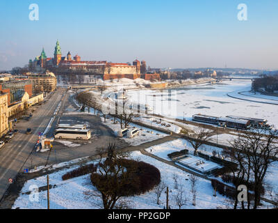 Krakau, Polen, im Winter. Antenne Skyline im Sonnenuntergang Licht mit Schloss Wawel, Kathedrale, teilweise gefrorene Weichsel mit Hafen, Schiffe, Grunw Stockfoto