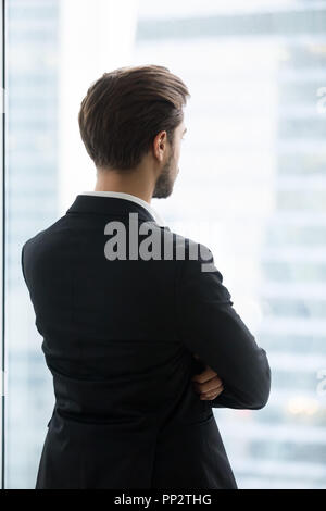 Nachdenklich männlichen Arbeitnehmer für zukünftige Projekte suchen im Fenster Stockfoto