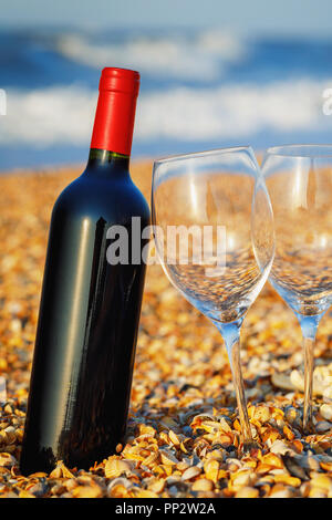 Versiegelte Flasche Rotwein mit zwei wineglass nahe am Strand bis Stockfoto