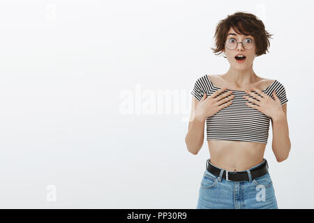 Innen- schuss von überrascht und erstaunt Suchen urban Freundin in runde Gläser und 7/8-Tank Top, Palmen auf der Brust, mit geöffnetem Mund und Augen geknallt, beeindruckt. Stockfoto