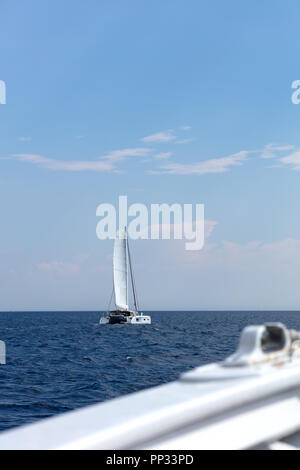 Weißen Katamaran Segeln entlang der italienischen Küste mit einer ruhigen, blauen Meer Foto von der Seite von einem anderen Boot genommen Stockfoto